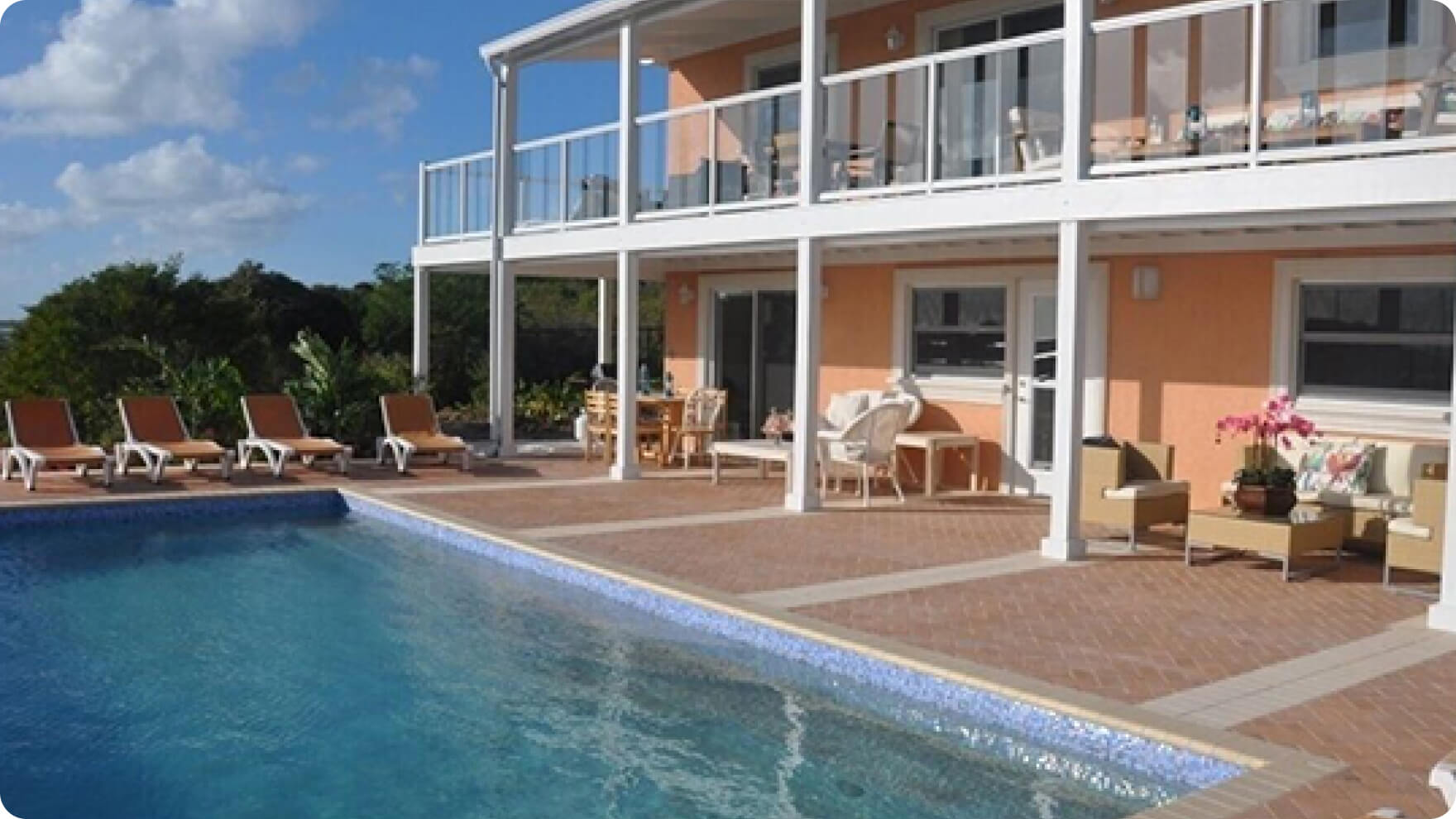 Una casa con una piscina y muebles al frente
