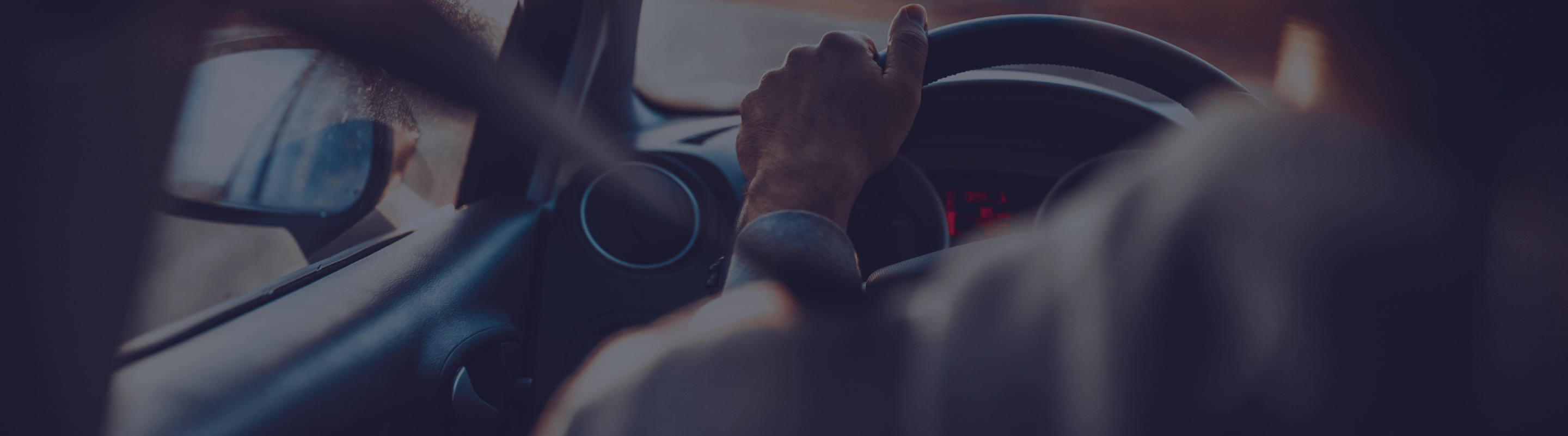 Primer plano de unas manos agarrando el volante de un coche.