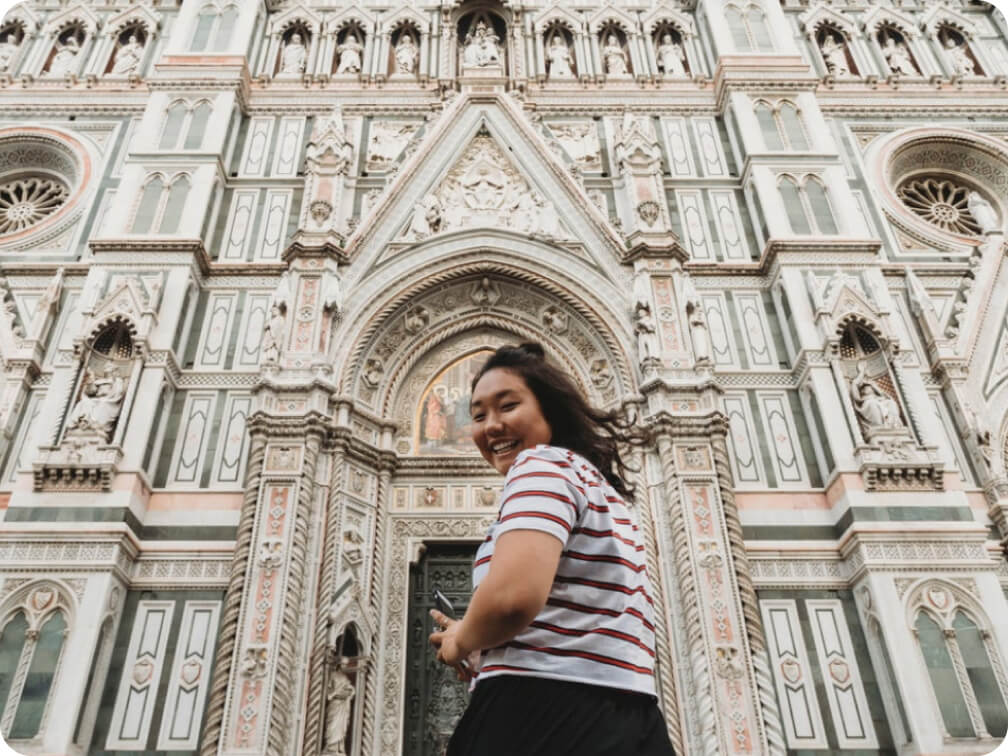 Woman standing in front of a gothic styled cathedral
